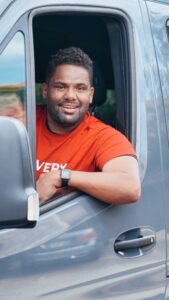 A smiling man driving a truck
