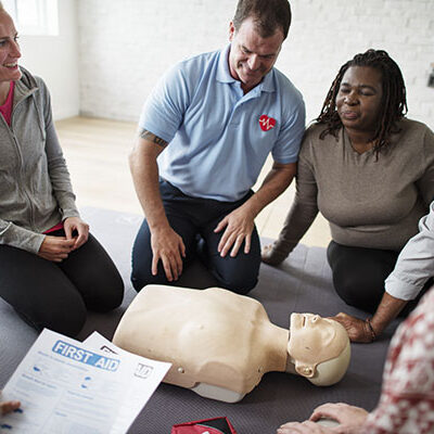 A person teaching a group to do CPR