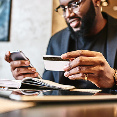A man holding his credit card and phone